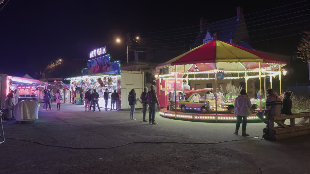 Nighttime funfair in Montrichard Val de Cher France with people and a carousel in a lively setting