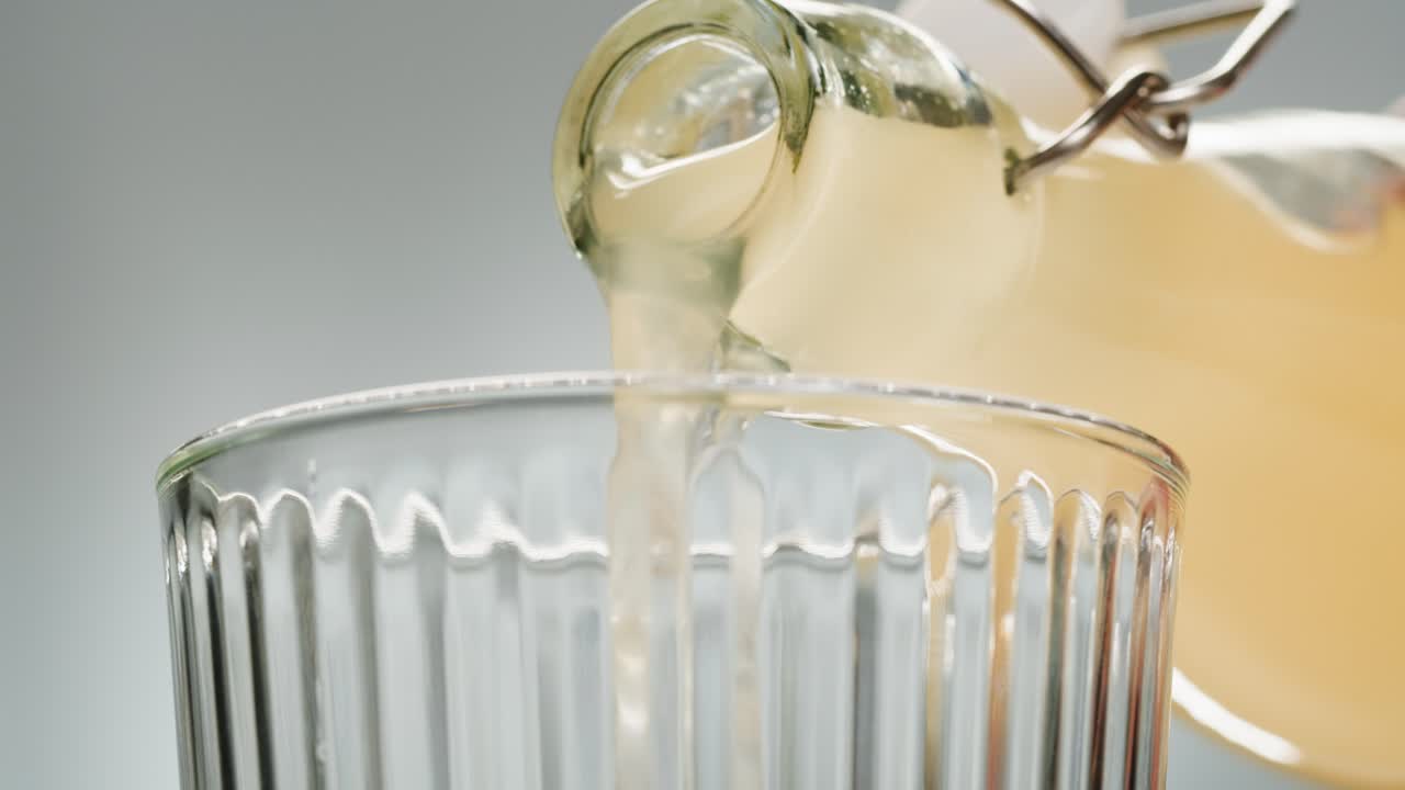 Orange or white wine bottle and glass, spanish french apple cider pouring, pouring of ecological natural wine.