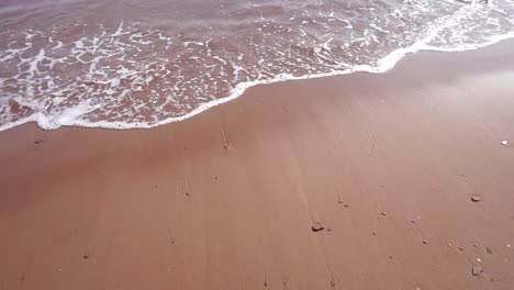 Playa-De-Arena-Roja-Con-Olas-Salpicadas