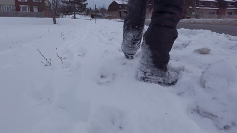 Kleines-Kind-Läuft-Im-Winter-In-Grauen-Schneehosen-Und-Schneestiefeln-Im-Schnee-Am-Straßenrand