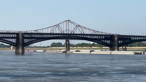 Static-shot-of-a-tug-boat-pushing-a-barge-vessel-under-the-Martin-Luther-King-Bridge-in-St