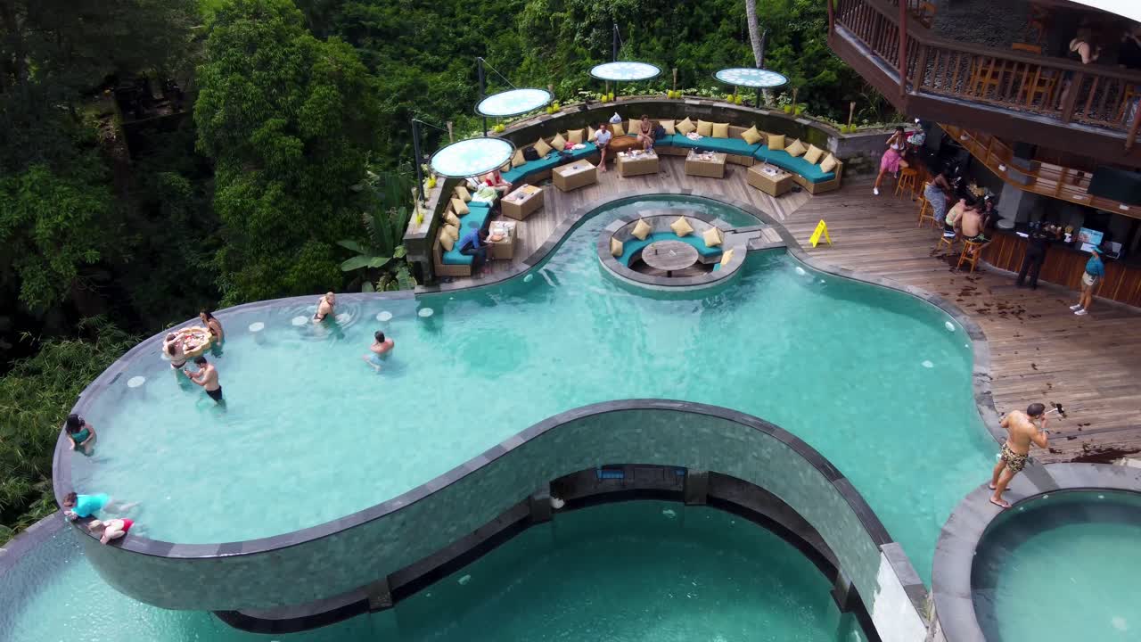 Aerial view of a luxury resort with multiple swimming pools nestled in a lush tropical jungle