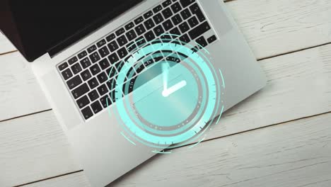 animation of neon ticking clock against close up of laptop on wooden table