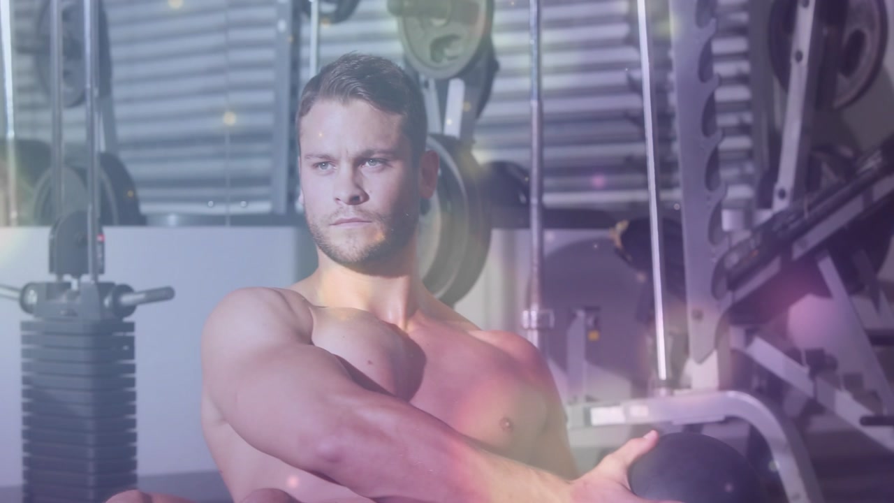 Man doing medball twists for fitness, from chest hold, building core under purple yellow flare