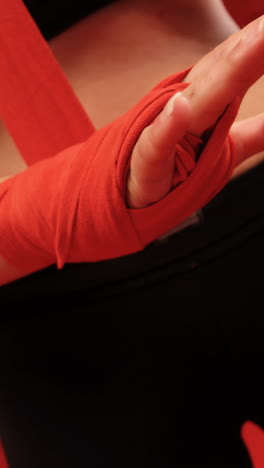 female boxer wearing red strap on wrist in fitness studio