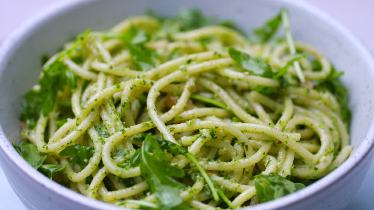 cuenco de espagueti con pesto y cohete