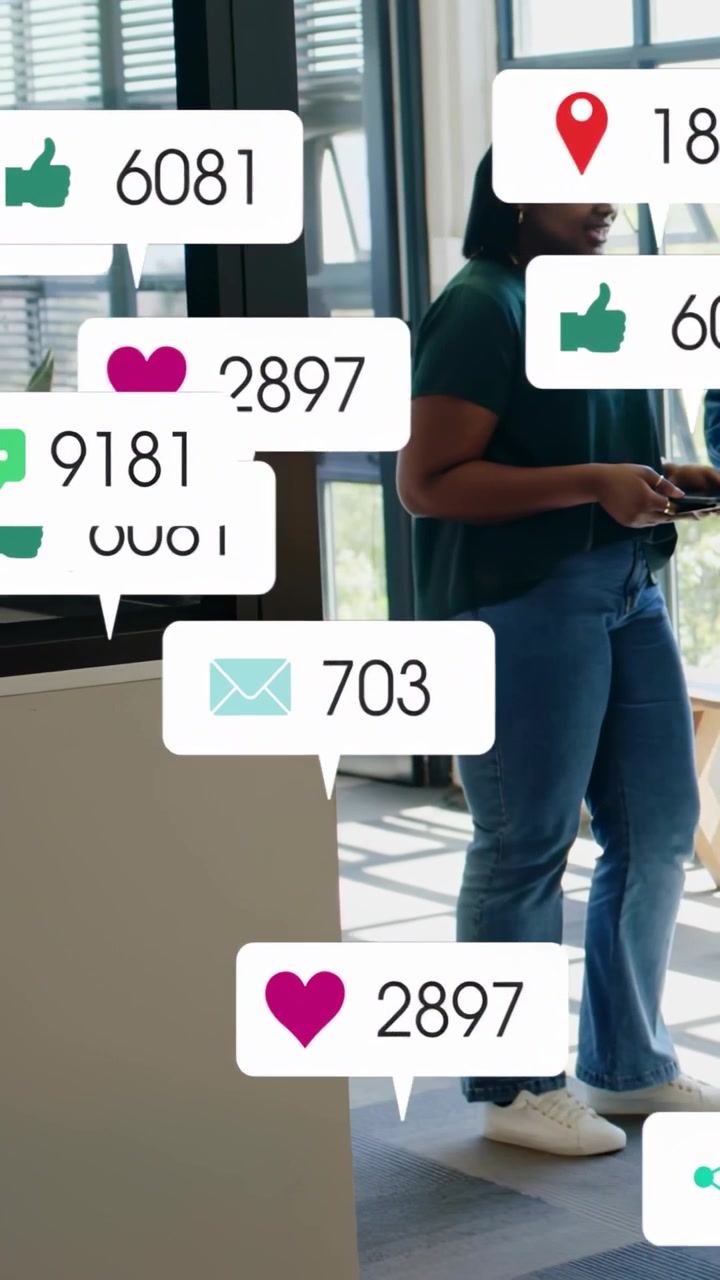 Vertical video: Woman holding device in office, social alerts popping, blocking view for marketing
