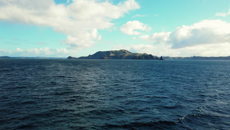 Scenery-Of-Beautiful-Blue-Ocean-With-Distant-Island-Under-Blue-Sky-And-Clouds-In-Bay-Of-Islands,-New-Zealand