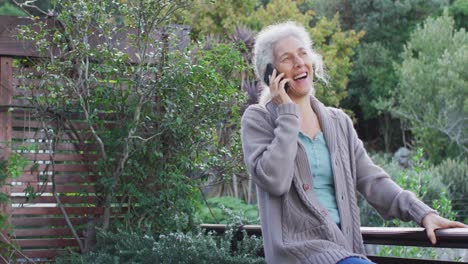 Portrait-of-senior-mixed-race-woman-talking-on-smartphone-on-balcony