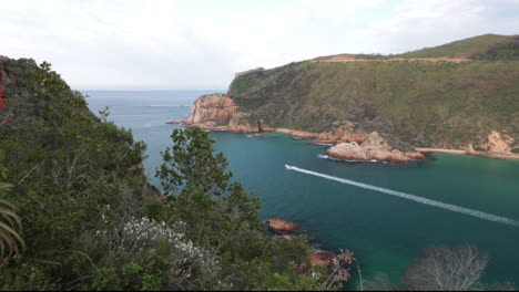 a beautiful summers day overlooking the knysna heads from a viewpoint with boats coming in and out of the indian ocean