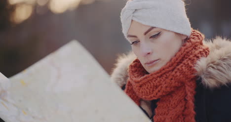 female tourist reading map in woods in winter 3