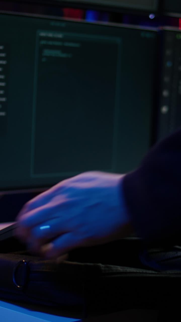 Video verticale: criminale informatico che prende un notebook dalla borsa e inizia a lavorare su uno script malware