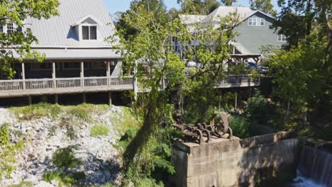 Aerial-fly-over-of-Buck-Creek-waterway-approaching-small-town-shops-and-eateries-in-Old-Town-Helena,-Alabama