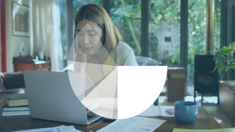 woman typing on laptop in home office, showing floating bar charts and financial icons