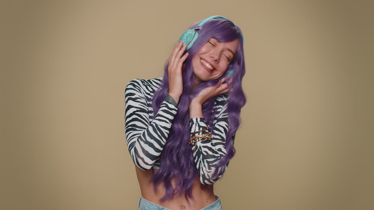 Happy pretty relaxed woman listening music on headphones and dancing disco fooling around having fun