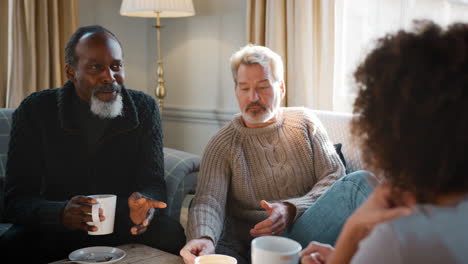 pull focus shot of middle aged friends meeting in coffee shop