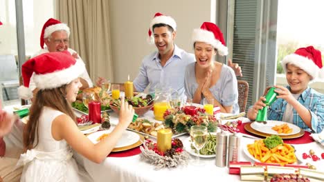 Siblings-pulling-a-christmas-cracker-at-the-dinner-table