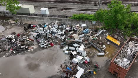 rain puddle and junkyard metal in industrial area of american town. aerial top down shot. railway and tracks in suburb.