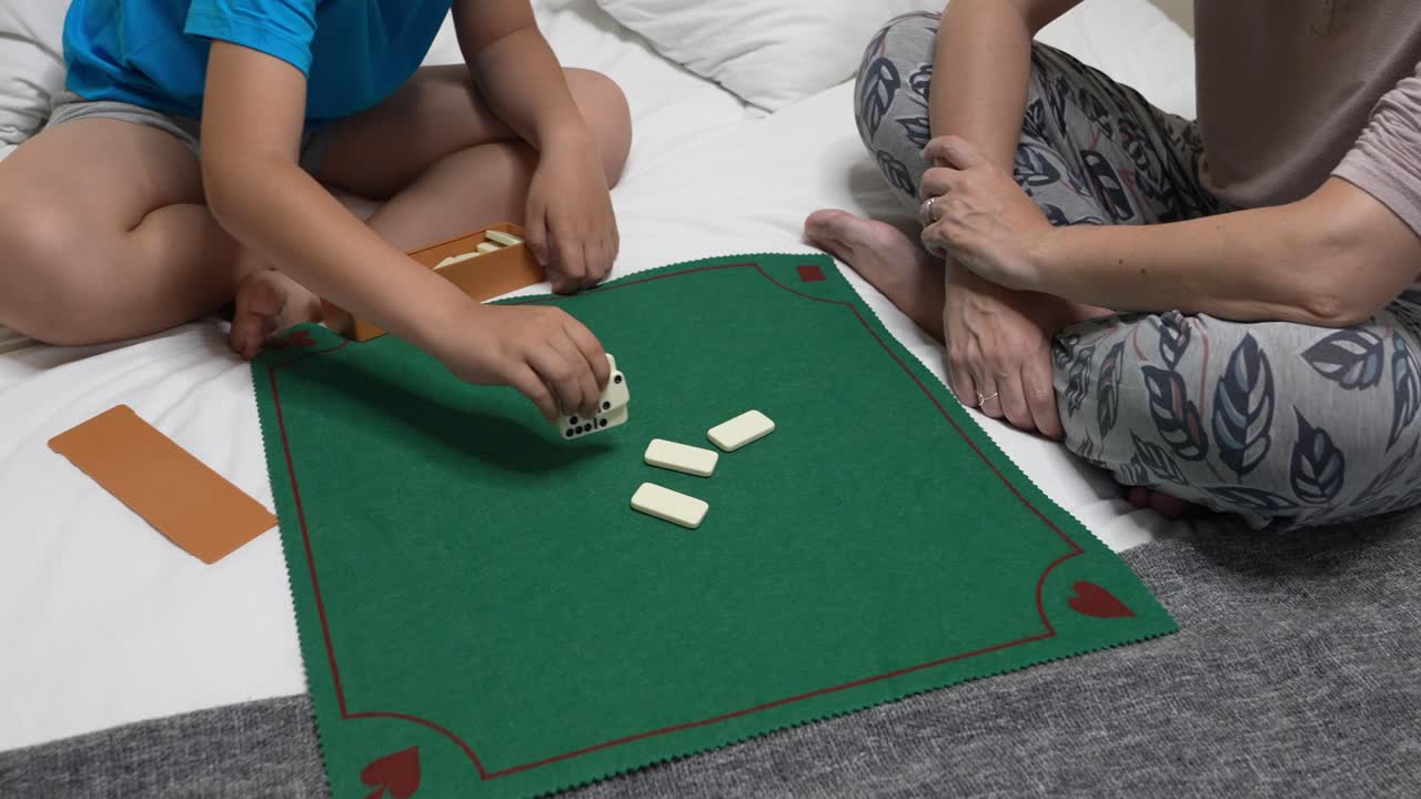 Famiglia che gioca a domino sul letto