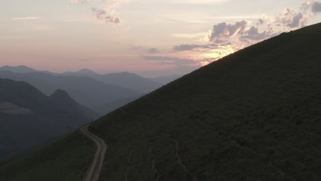 rural road on slope of mountain with sunset in background, iraty on atlantic pyrenees, france