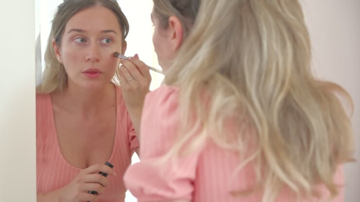 Primo piano di una donna che si trucca allo specchio