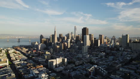 Aerial-view-rising-in-front-of-high-rise-in-San-Francisco,-sunrise-in-CA,-USA