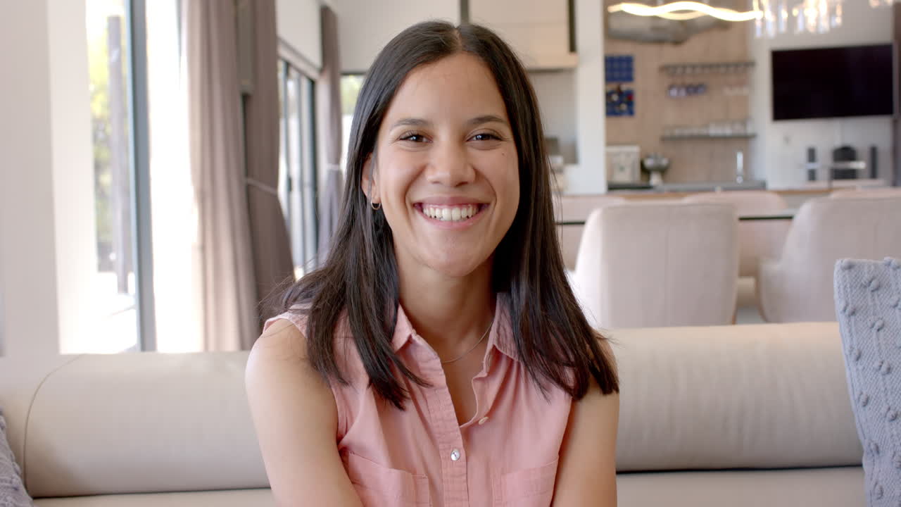 Smiling teenage girl sitting on couch, enjoying time at home