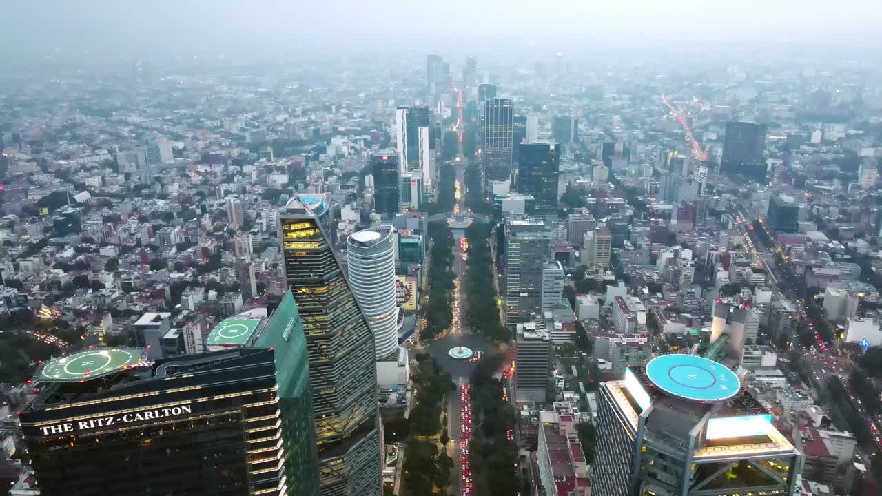vista aérea inclinada hacia arriba del paseo de la reforma, la principal avenida turística de la ciudad de méxico con los edificios iluminados en un día nublado