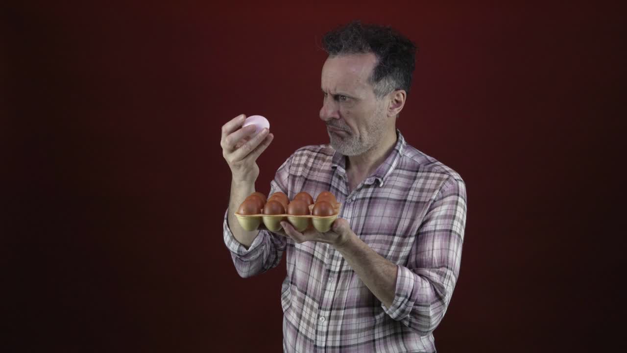 Man surprised by a pink egg among brown eggs