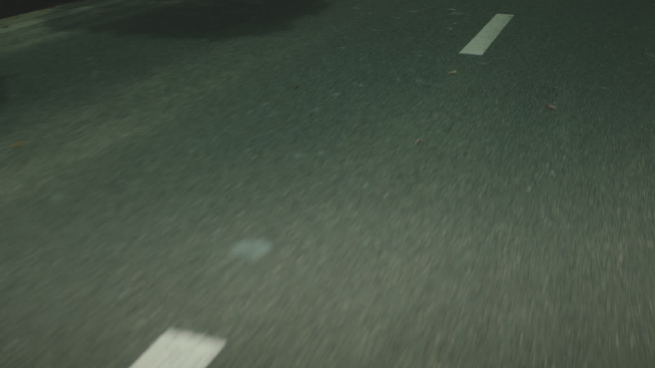 Primo piano di linee bianche tratteggiate mentre si guida su un'autostrada. Rallentatore.