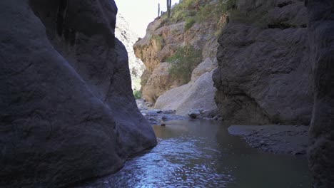 Water-stream-flowing-between-steep-rocky-cliffs