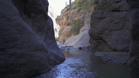 un arroyo de agua que fluye entre escarpados acantilados rocosos