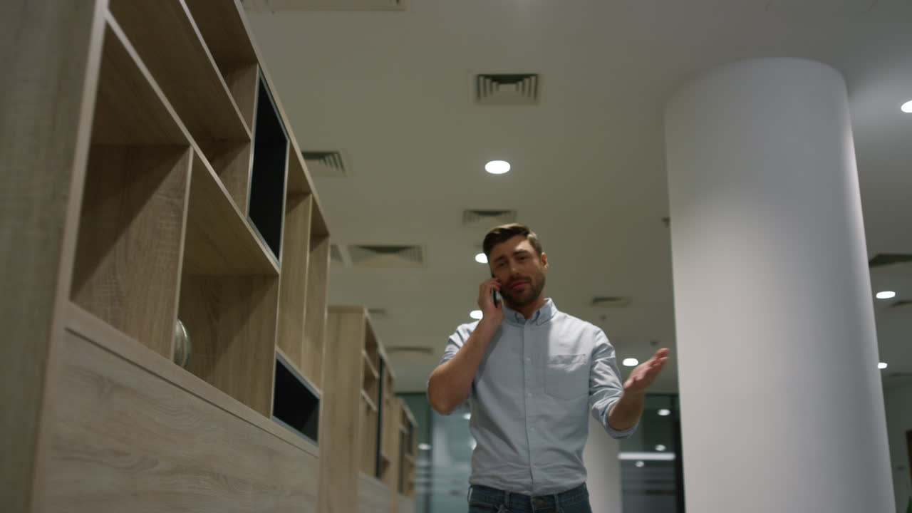 hombre de negocios positivo hablando por teléfono discutiendo el plan corporativo en la oficina de la compañía.