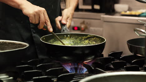 chef cooking creamy sauce over a medium fire in the kitchen of a restaurant