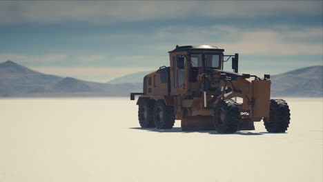 road grading machine on the salt desert road