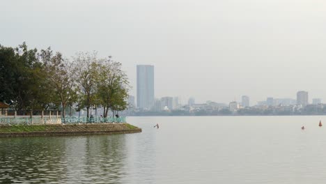 city buildings on distant shoreline, traffic commuting near water edge