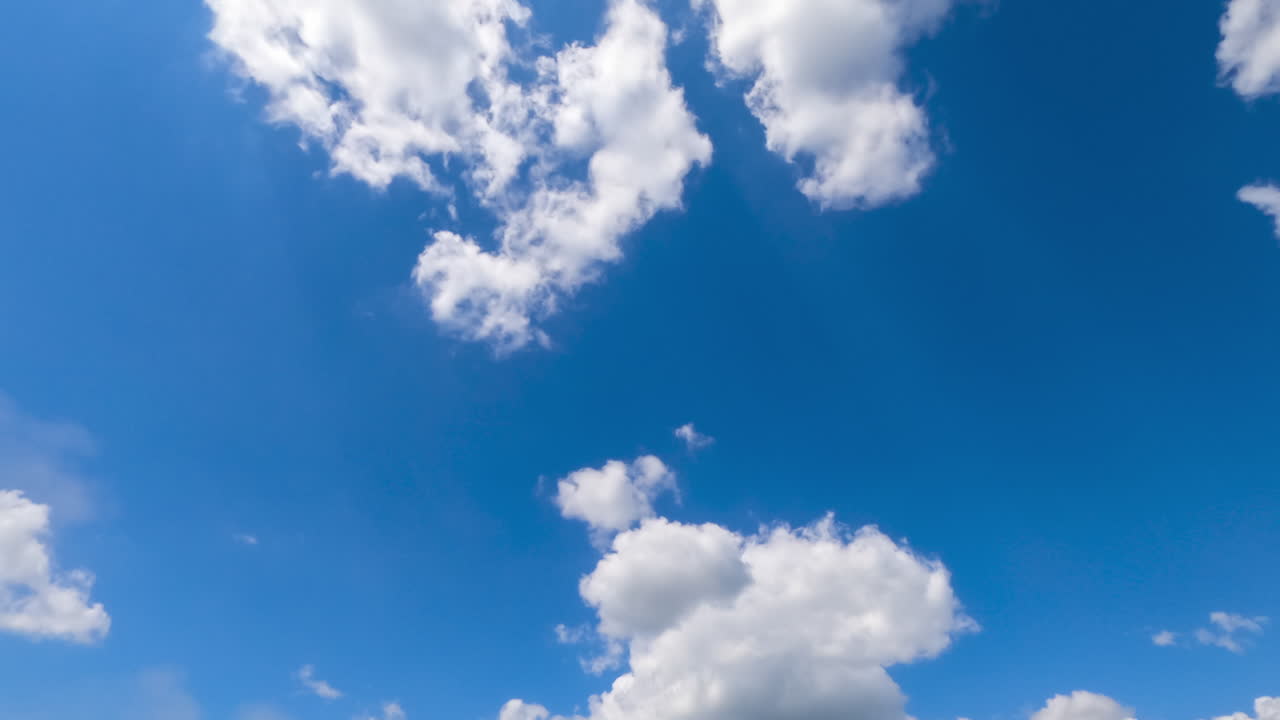 White light soft clouds flying in the sky. Sunny day background. Low angle view. Timelapse.