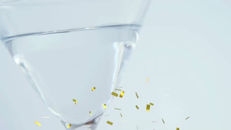 Animation-of-confetti-falling-over-cocktail-glass-on-white-background