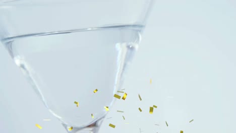 animation of confetti falling over cocktail glass on white background