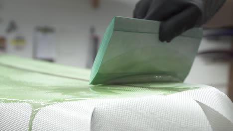 surfboard being glassed and painted slow motion using squeegee