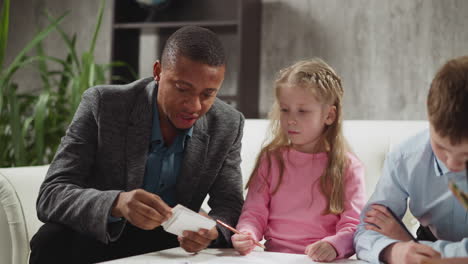 black teacher shows cards telling letter names to children