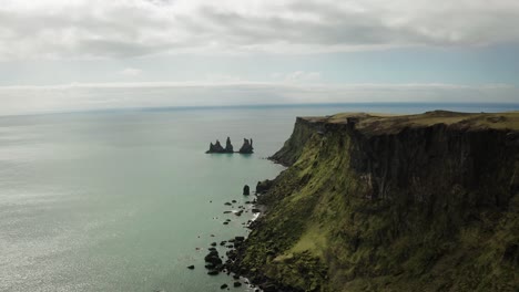 Toma-Aérea-De-Islandia,-Acantilado,-Rocas,-Océano-Sin-Fin-En-Vík