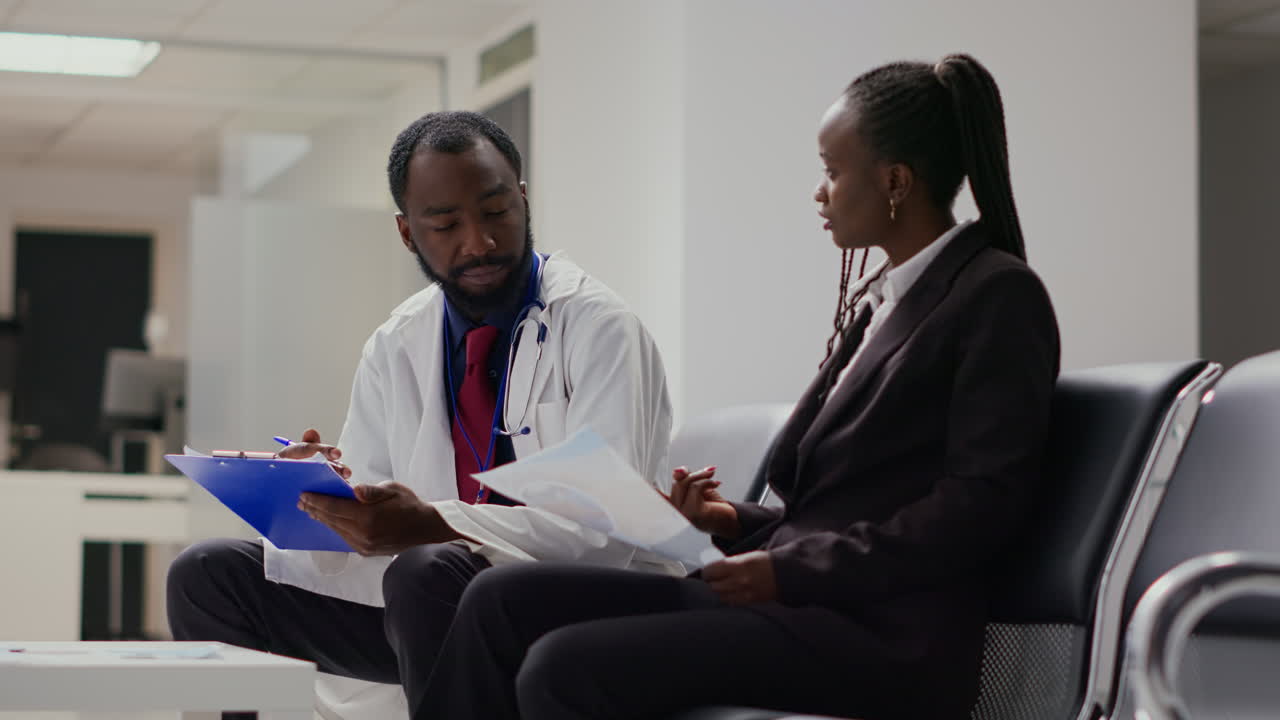 Health specialist talking to woman about recovery in hospital reception