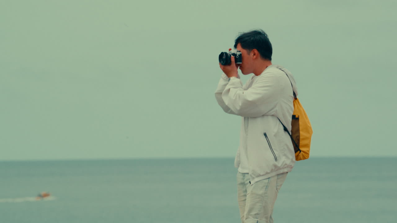 hombre tomando una foto en la playa