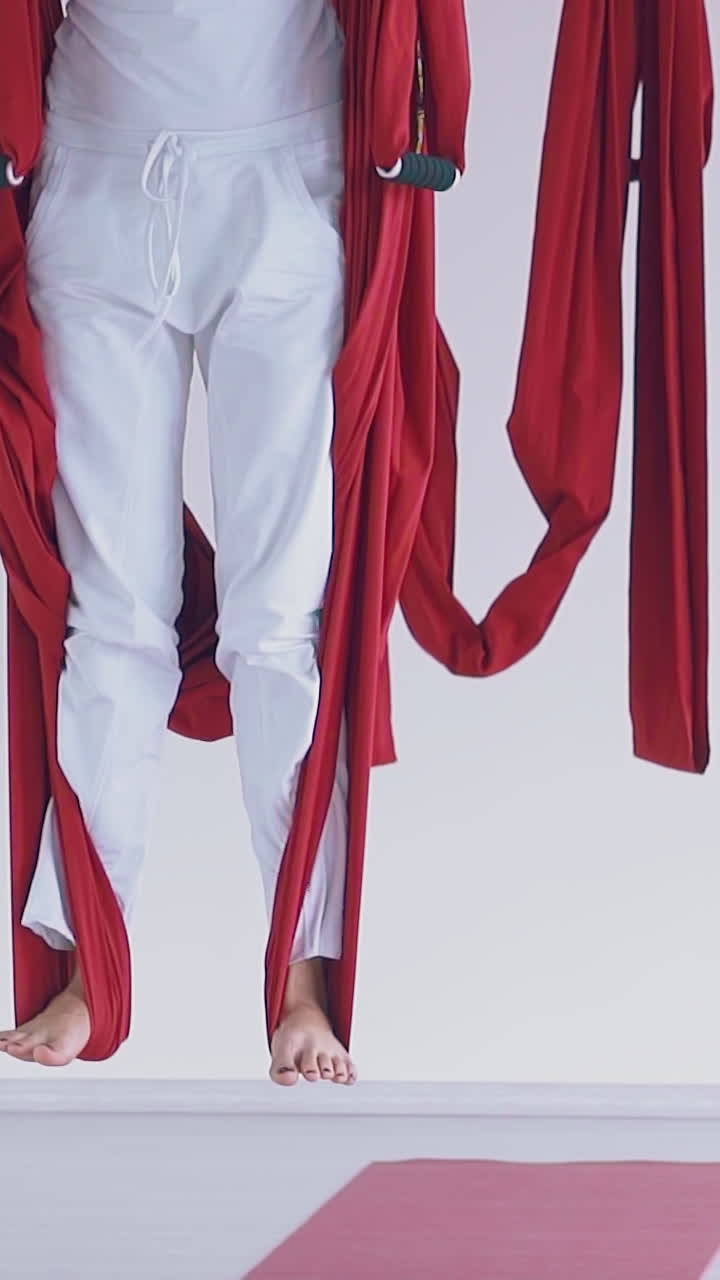 ladies group legs stand on special fly yoga hammocks strip practicing modern asana close view slow motion