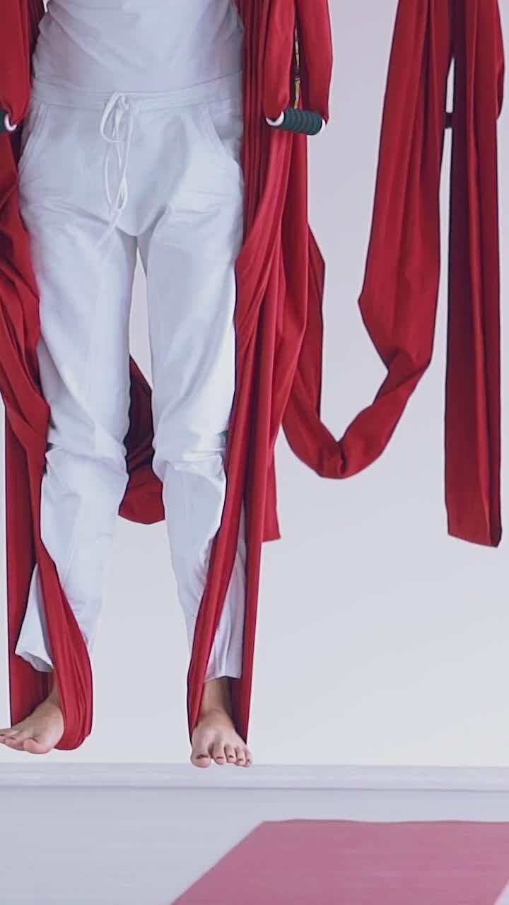 ladies group legs stand on special fly yoga hammocks strip practicing modern asana close view slow motion