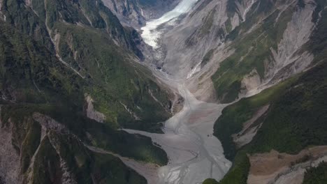 Fox-Glacier,-New-Zealand---aerial-tilt-up-over-the-valley-reveal-of-amazing-landscape