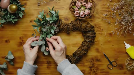 las manos hacen coronas florales de pascua para la decoración del hogar.