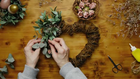 hands makes easter floral wreath for home decor.