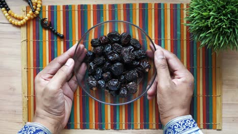 the concept of ramadan, hand pick date fruit from a bowl